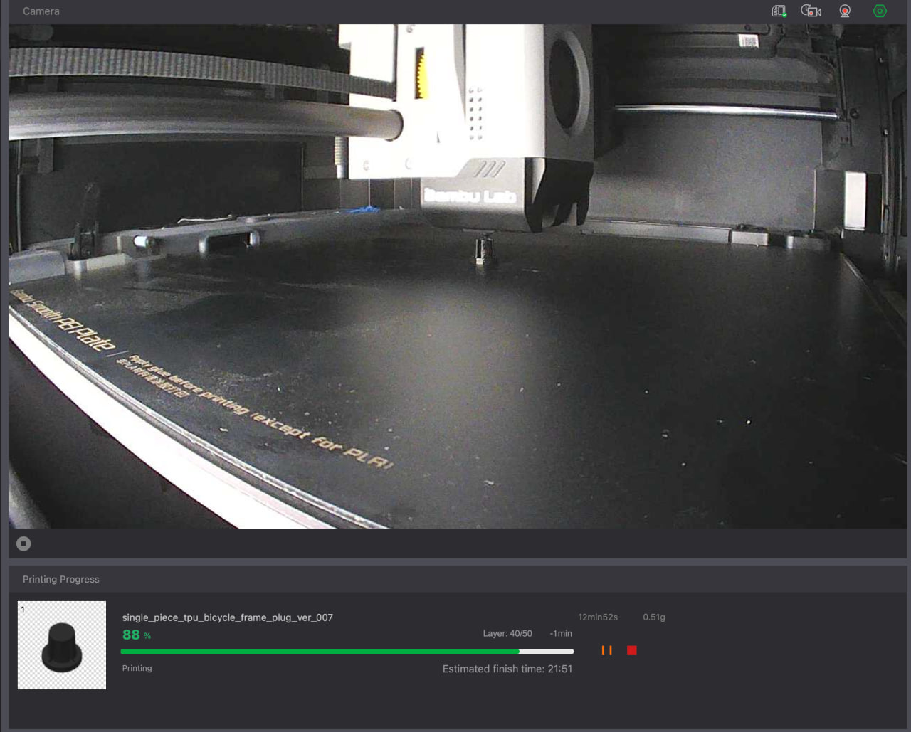 3D printer camera view showing the bicycle-frame plug printing