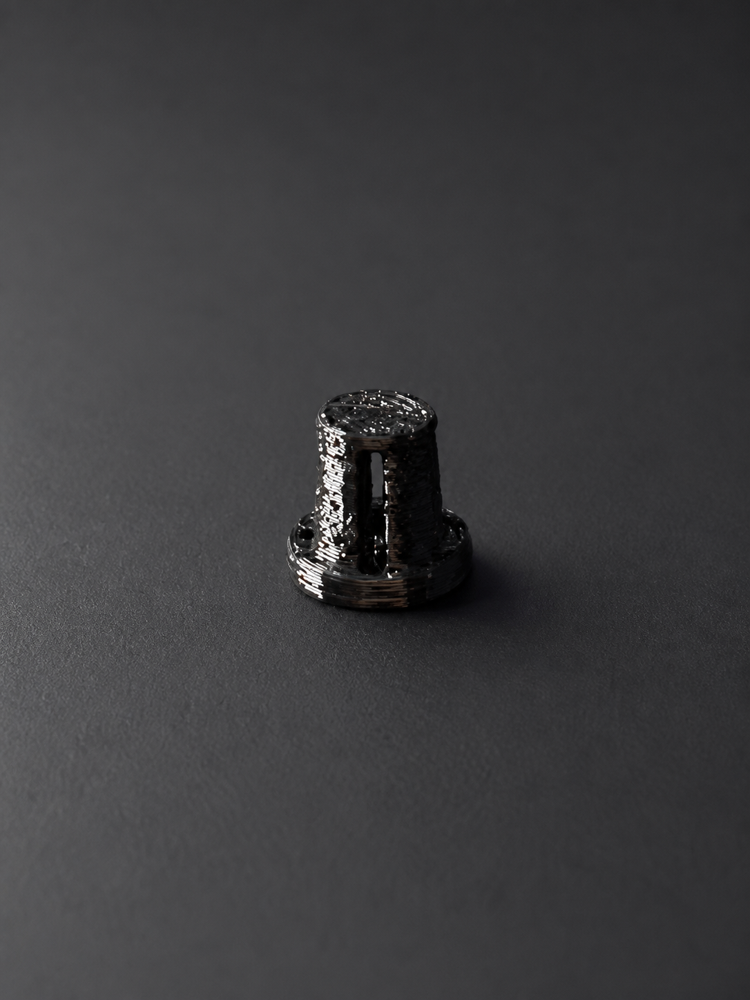 Studio treatment of the printed black TPU bicycle-frame plug with longitudinal slots